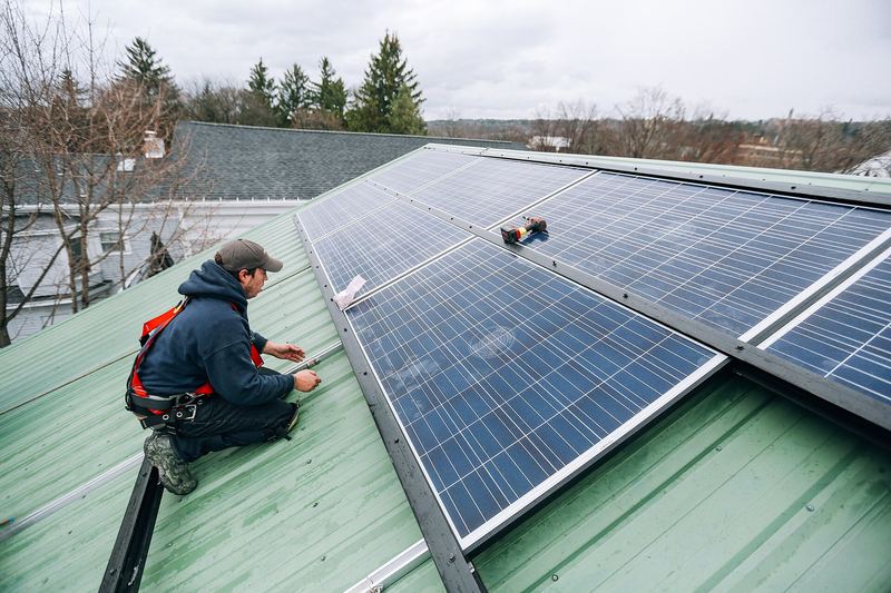 Solar installers working on a rooftop photovoltaic array